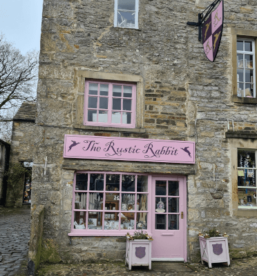 The front of the Rustic Rabbit tea room in Grassington. It's a stone end-of-terrace building with woodwork painted in pale pink.