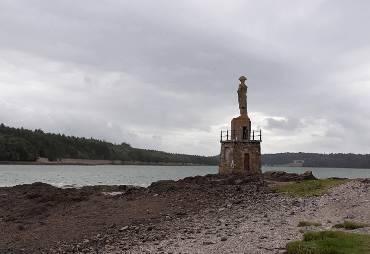 Statue of Admiral Nelson on the end of a pebbly beach