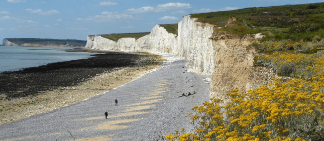 A pebbly beach lies beneath white cliffs near Eastbourne on the South Downs Way.