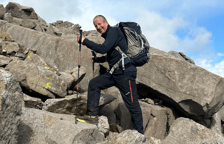 A walker on a more strenuous hike up Scafell Pike deploys walking poles for balance.