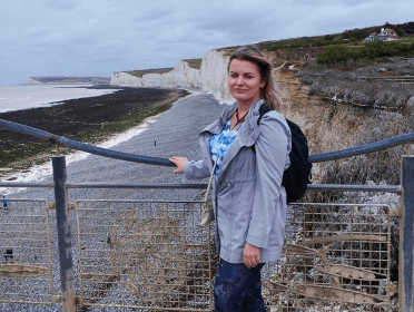 Gosia stands on a safe viewing platform with Seven Sisters behind her.