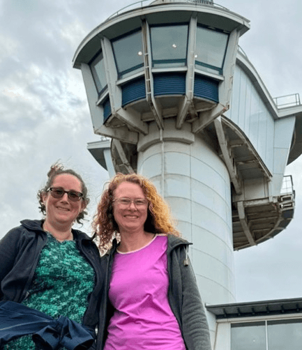 Laura and Liz pose together beneath the viewing tower at Segedunum Roman Fort in Wallsend at the end of Hadrian's Wall Path.