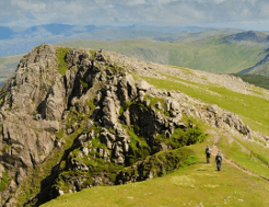Challenge walkers ascend a rocky path atop Pillar in the Lake District.