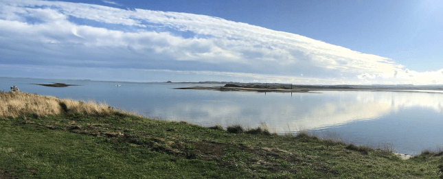 Looking toward Bamburgh from Holy Island on the Northumberland Coast Path walking holiday.