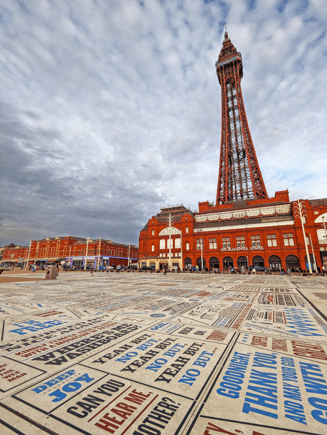 Blackpool Tower stands over the famous Comedy Carpet, printed with jokes by famous comedians.