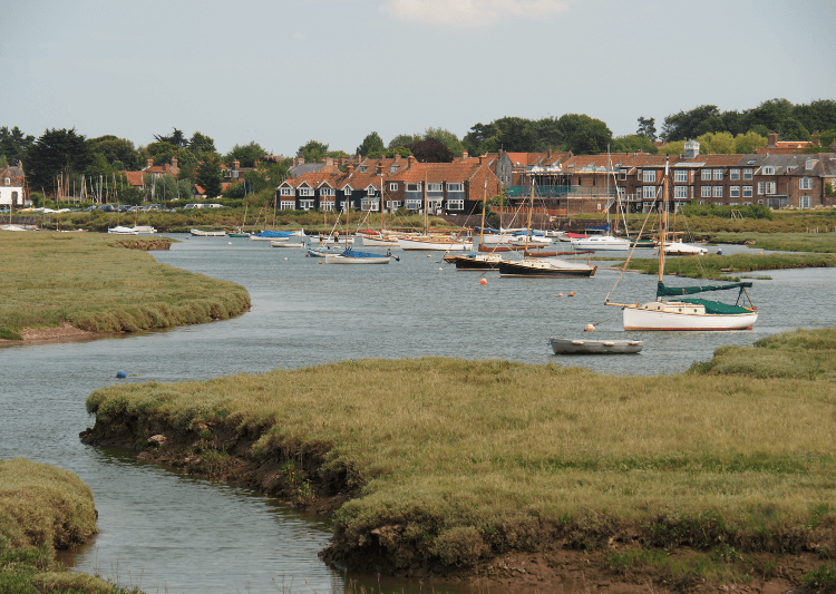 The red brick houses of Brancaster Staithe stand above the sea on one of the top five coastal walks in the UK