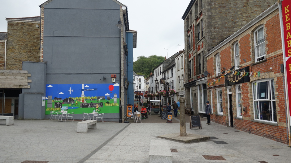 A colourful mural of a sunny day on a pub wall