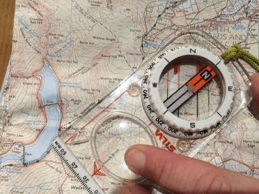 A compass sits atop an Ordnance Survey map.