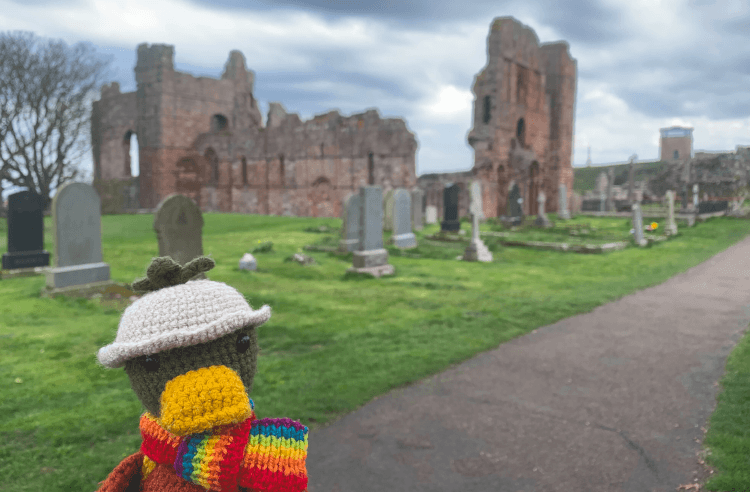Croutons stands in front of the ruins of Lindisfarne Priory on Holy Island in Northumberland.