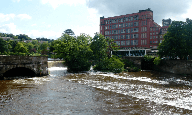 A red industrial building stands above the water on the Derwent Valley Heritage Way, just as stunning in winter as in summer