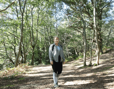 The author stands on a path through established woodland.