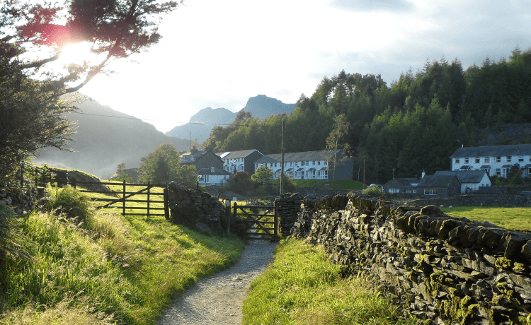 A path leads the way through a gate at the edge of a village, a great example of a familiar local walk to try out solo.