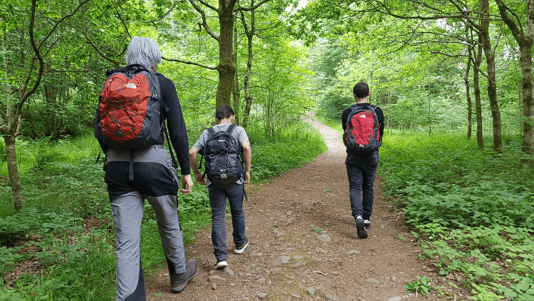 A family walks through a wooded area together.