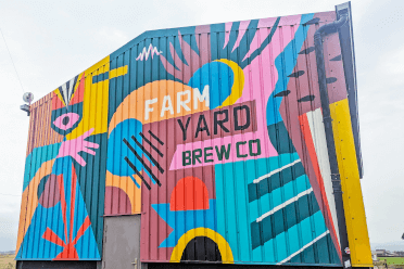 A brightly painted barn depicting the Farm Yard Brew Co logo.