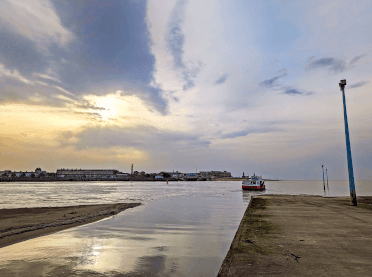 Views from the jetty across the River Wyre, with the tiny passenger ferry arpproaching.