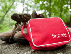 First aid kit next to a pair of walking boots