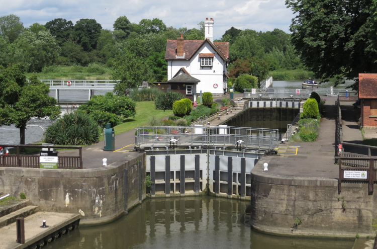 Goring Lock, with a traditional whitewashed house in the background and trees all around.