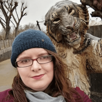 Grace, tour operations administrator, takes a selfie beneath a carved wooden tiger.