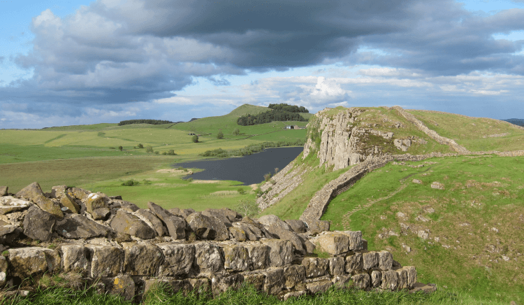 Hadrian's Wall (and the walking path that shadows it closely) rises and falls across the hilly Northumbrian countryside, leading off into the distance.