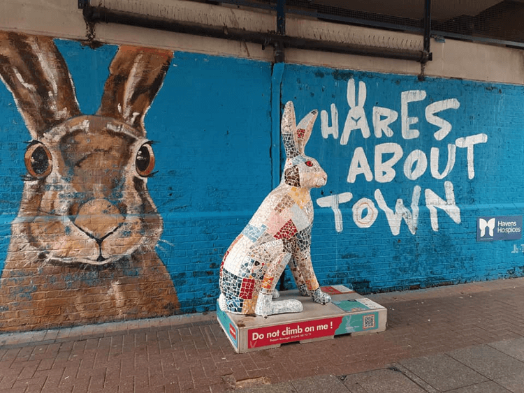 Art on the trail: a wall painting and statue of hares.