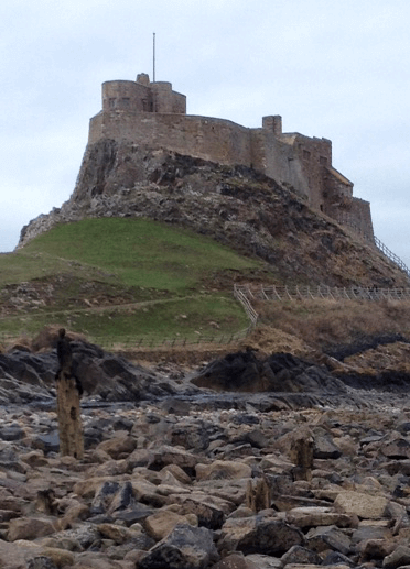 Holy Island, one of the most popular sights on the Northumberland coast, rises from the rocky bed of the causeway.