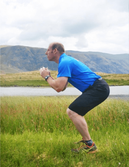 A fell-runner furthers the squat by sinking with his knees apart and back straight.
