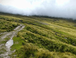 Inclement weather soaks the path and reduces visibility on the Pennine Way, a challenging, exposed National Trail.