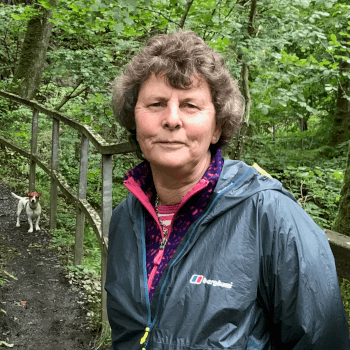 Karen, Managing Director at Contours Holidays, stands on a walking trail with her Jack Russell.