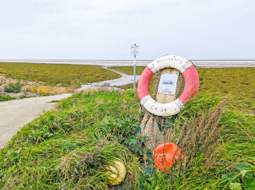 An old life ring stands at the side of the trail.