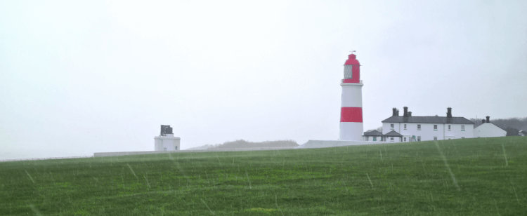 A lonely lighthouse in the lashing rain.