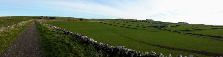 Minninglow hill rising in the distance above a footpath