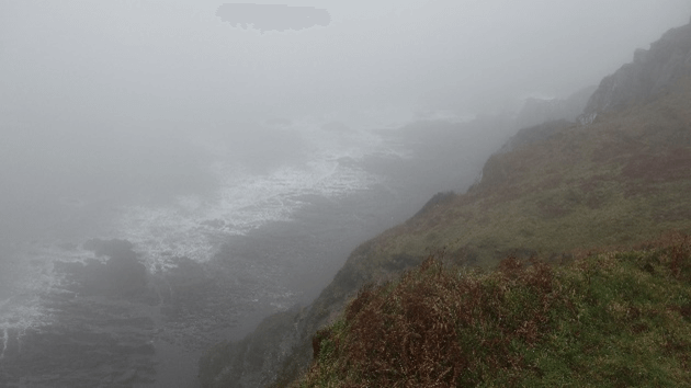 Mist shrouds the path and the sea below on the South West Coast Path.