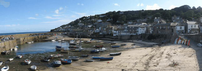 Boats nestle in Mousehole Harbour in good weather.