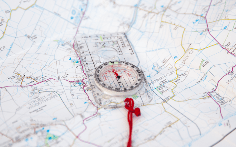 A compass sits on an open Ordnance Survey map.