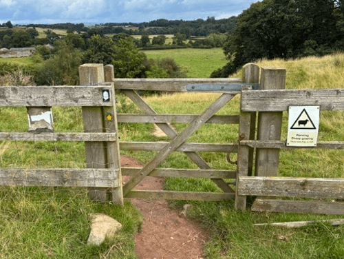The National Trails' acorn waymarker on a fencepost out on Hadrian's Wall Path.
