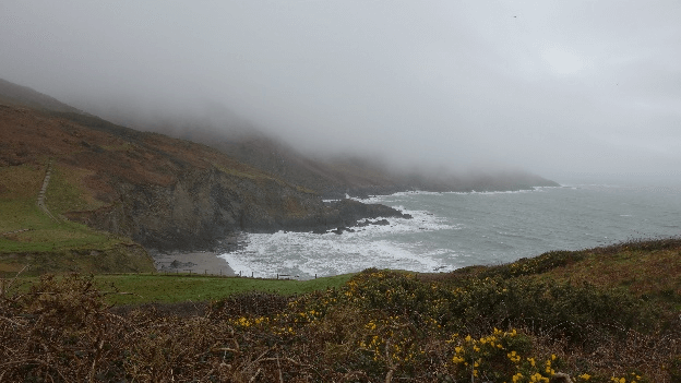 The weather gets worse, with low visibility through the fog crowding this narrow seaside path.