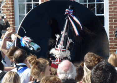 The Padstow Obby Oss, a wooden cone-shaped creation painted black, white and red, with ribbons and tassles attached, is paraded through the crowd in Padstow.