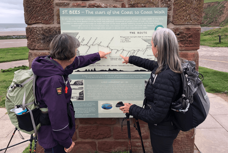 Plan your layers like you plan your route: two walkers study the route profile of the Coast to Coast Walk.