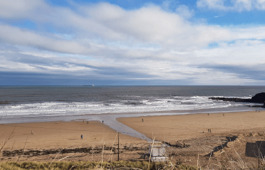 A sunny day lights up a rain-soaked beach on the South Northumberland Coast Path.