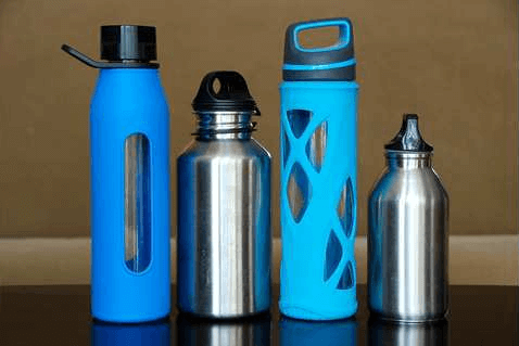 A series of environmentally friendly blue and metal water bottles sit in a row.