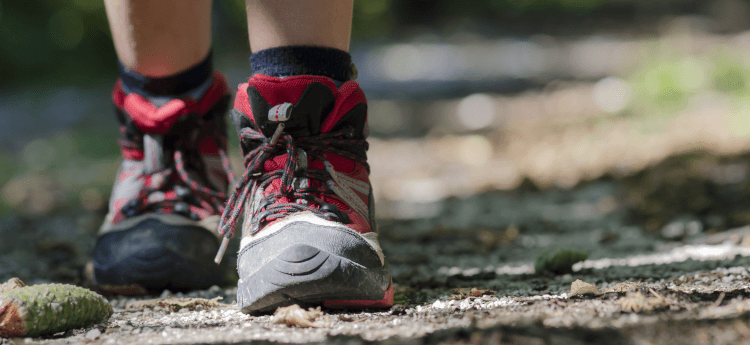 A hiker walking in well-fitted walking boots to prevent blisters.