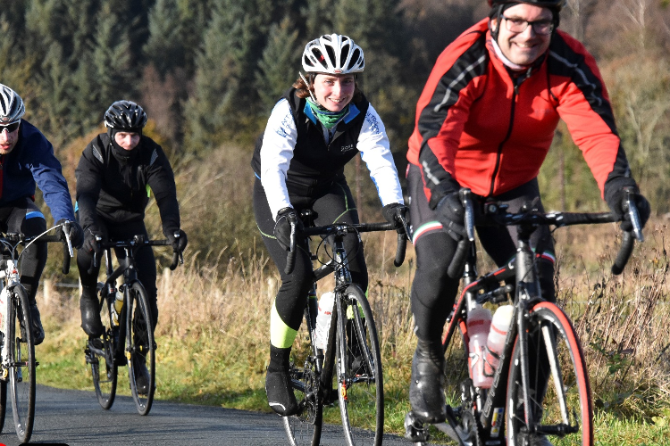 A group of cyclists riding in winter wearing jackets and gillets