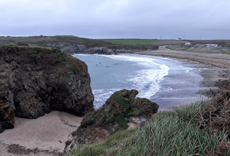 A rocky cove overlooking a sandy bay