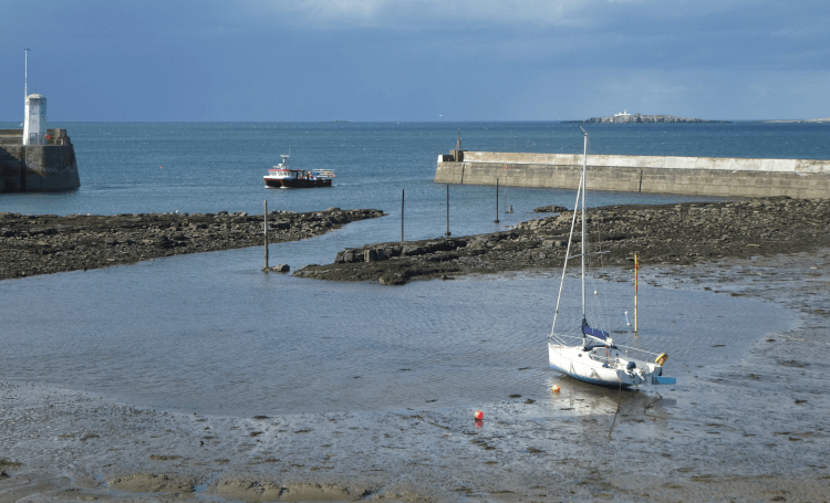 Views across the bay at Seahouses, with fishing boats bobbing on the blue water.