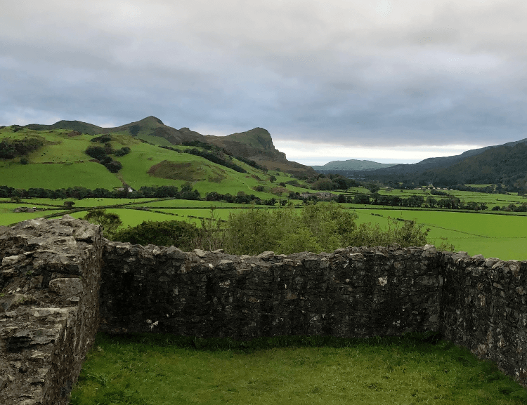 The view south from Castell y Bere: over green fields, the protruding stone of Bird Rock