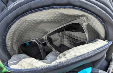 A pair of sunglasses sit inside the glasses pouch built into this rucksack.