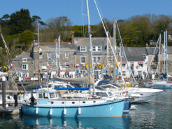 A blue sailboat in a harbour on the South West Coast Path.