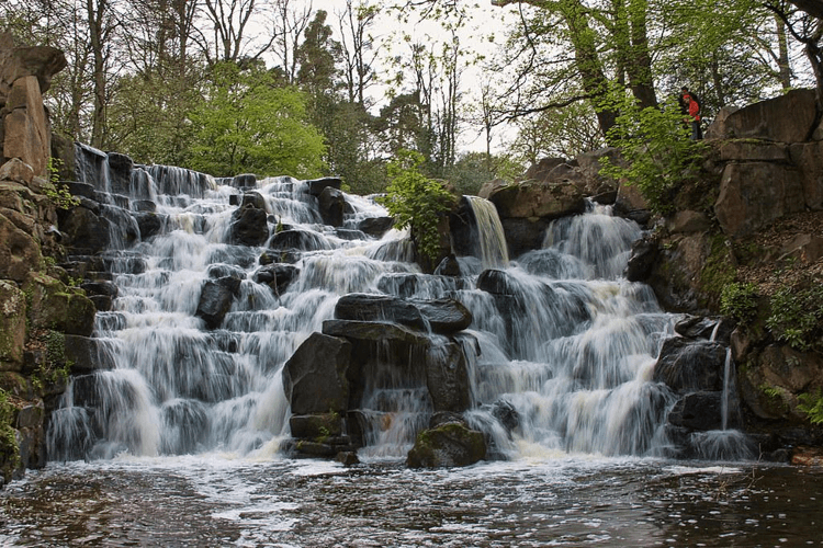 The Cascade at Virginia Water, Surrey, by Nana B Agyei on Flickr. A wide waterfall thunders in two diverging sheets over a wide man-made stone drop.