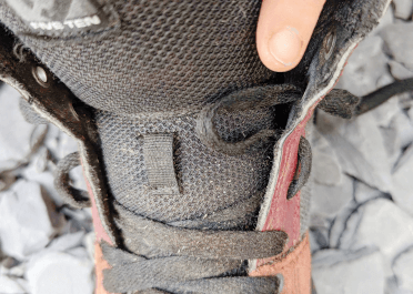 A red mountain biking shoe with a multi-eyelet gap laced in.