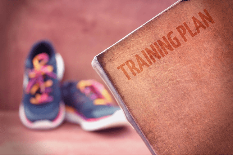 A written training plan in the foreground; walking shoes in the background.